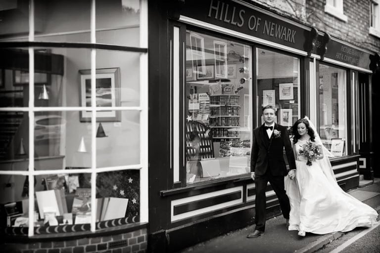 bride and groom walking past book store in Newark