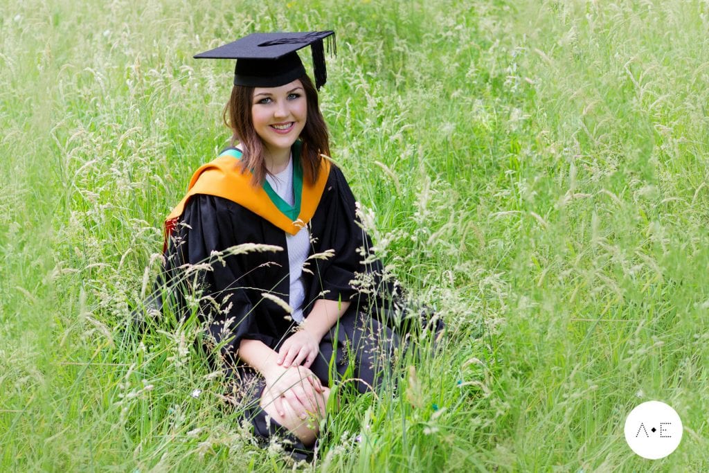 nottingham graduation photographer lady wearing gown in long grass