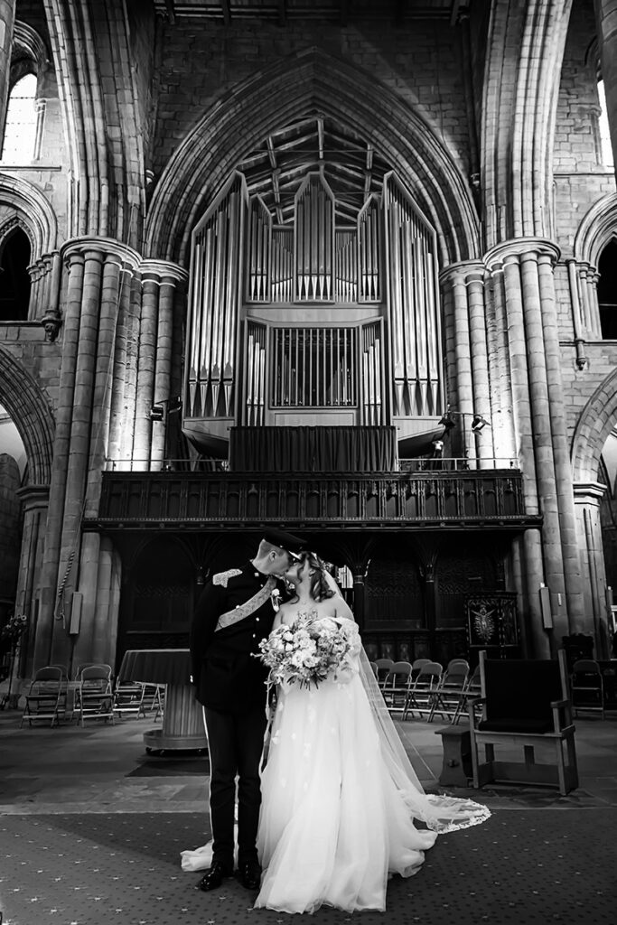 bride and groom kissing in HEXHAM ABBEY
