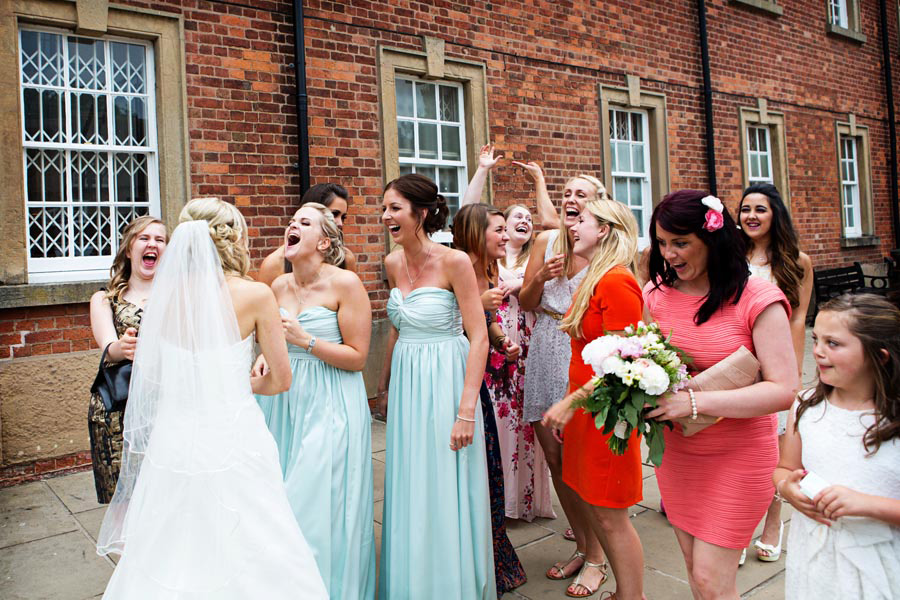 wedding guests laughing at bouquet throwing with bride