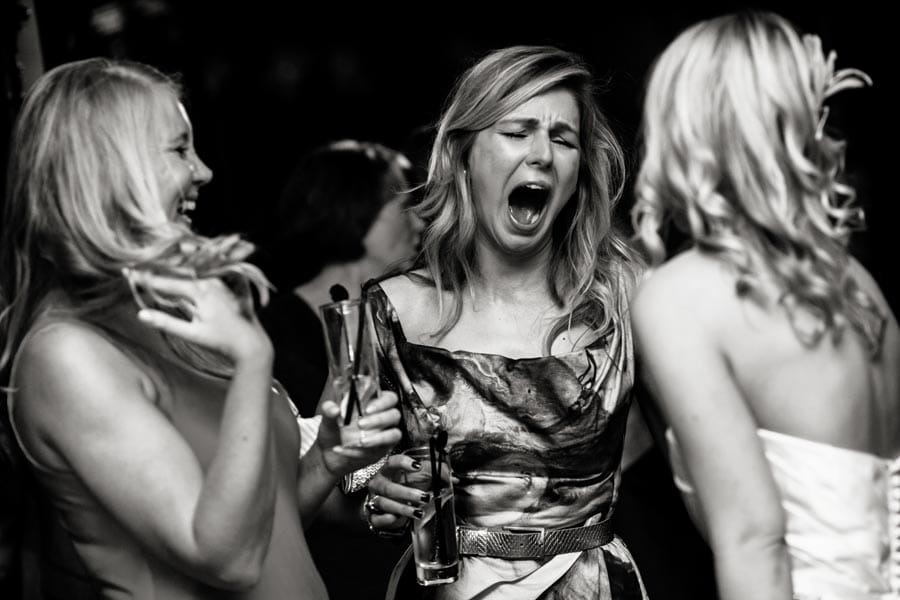 candid wedding photography of guests dancing and laughing at wedding
