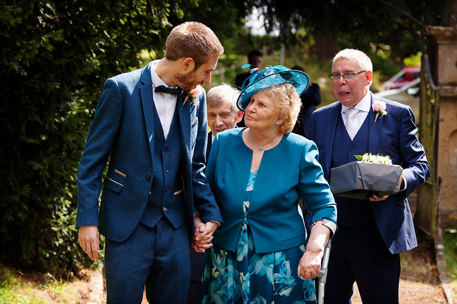 documentary wedding photog of groom walking grandma to church in Nottingham