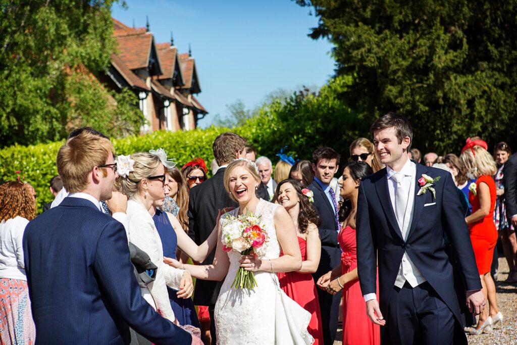 guests laughing outside church captured by marquee wedding photographer Alison Edwards