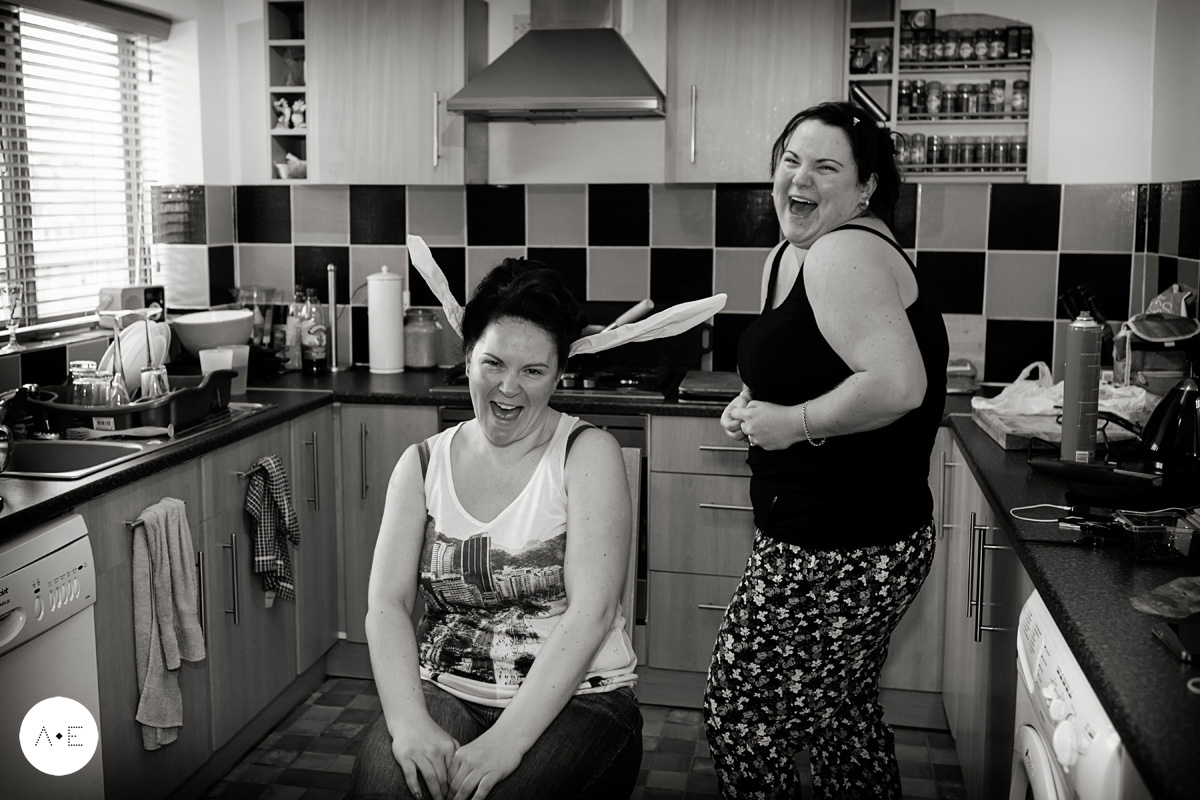 Bride and sister laughing during bridal preparations captured by Alison Edwards Photography Nottingham wedding photographer