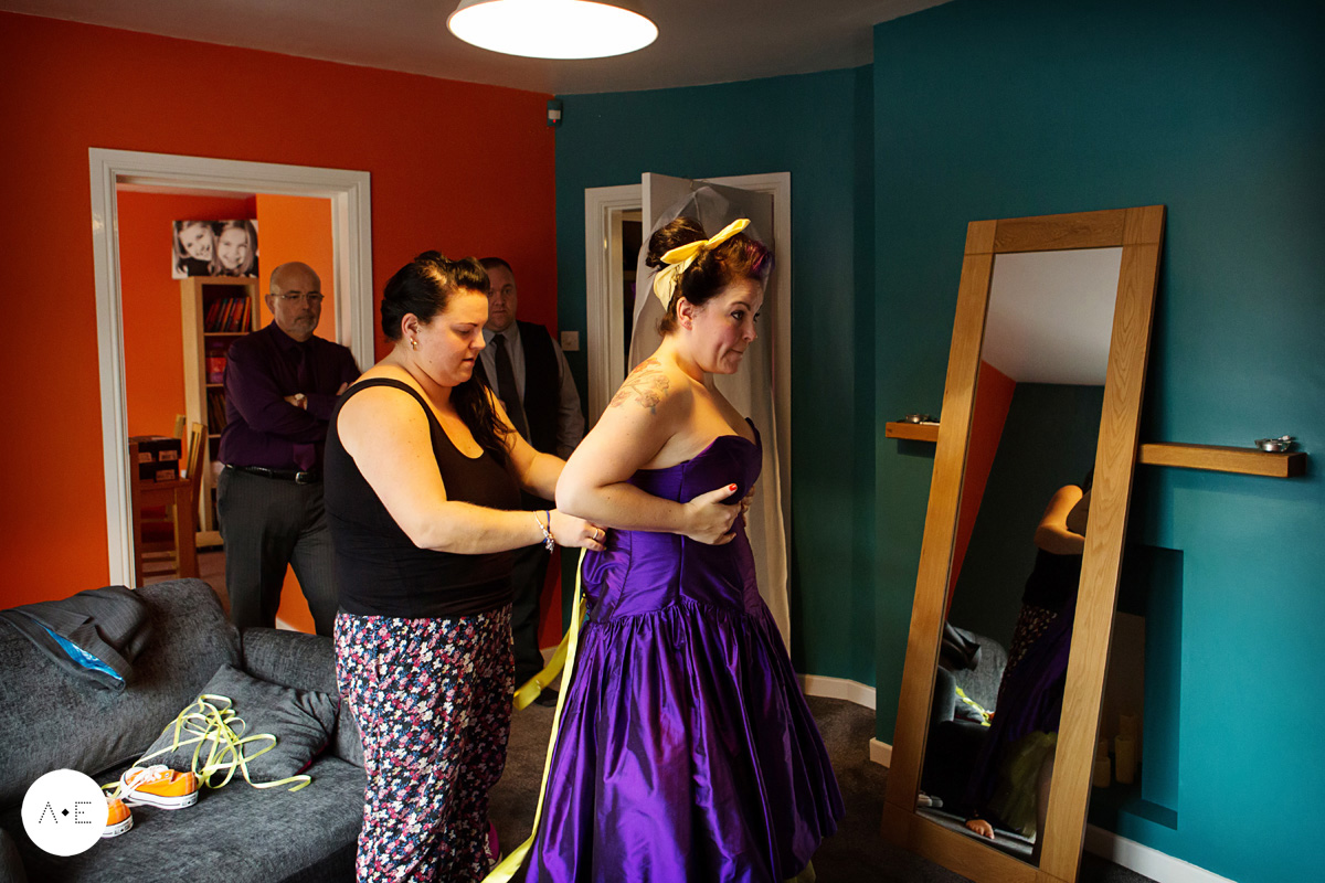 bride being tied into purple wedding dress captured by Alison Edwards Photography Nottingham wedding photographer