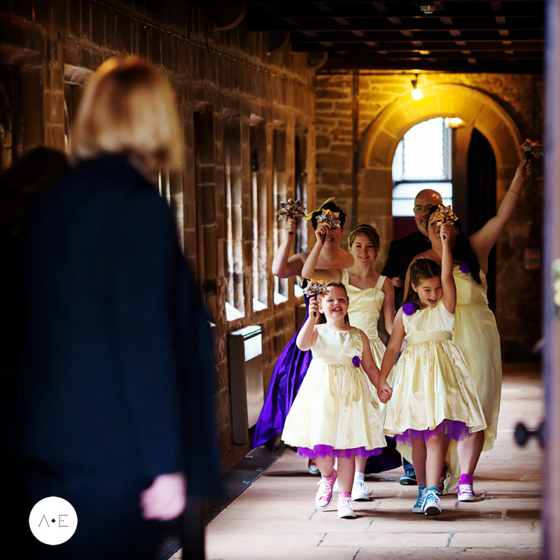 bride and bridesmaids walking into ceremony cheering captured by Alison Edwards Photography Nottingham wedding photographer
