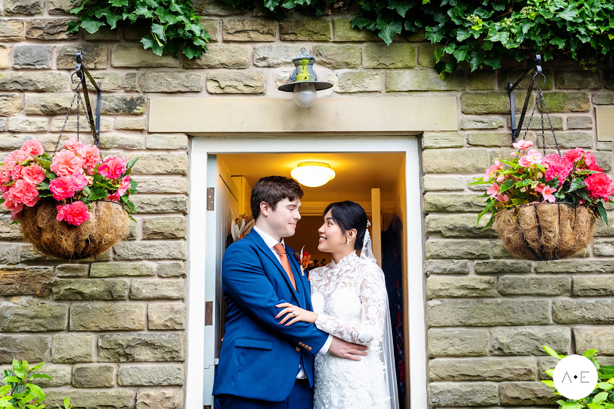 bride and groom portrait in doorway of country house in the Peak District photographed by Alison Edwards Photography