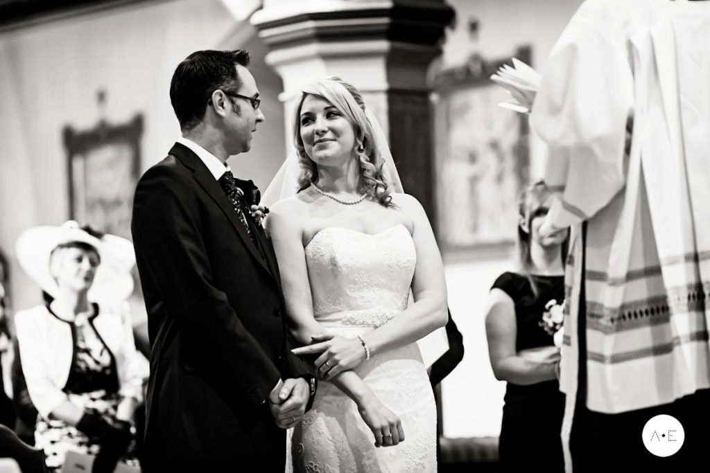 bride and groom smiling at alter taken with a documentary wedding photography approach