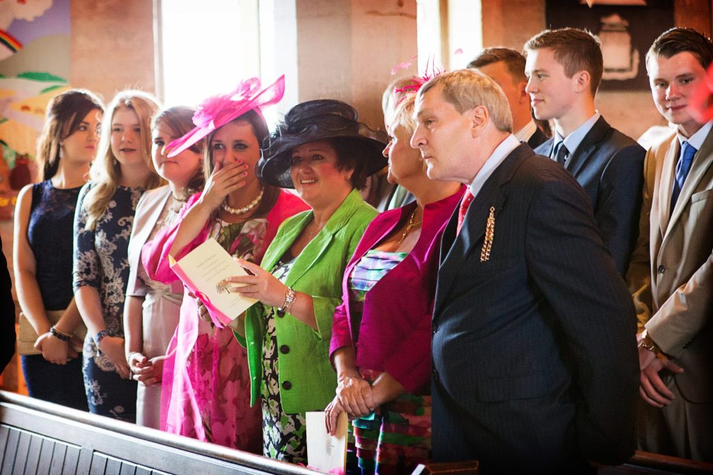 emotional wedding guests in church captured in a documentary wedding photography style by Alison Edwards Photography