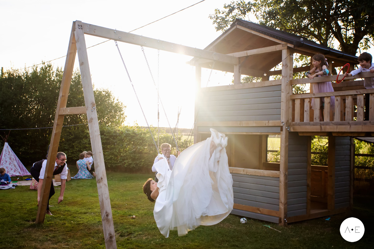 bride on swing in garden wedding captured by documentary wdding photography Alison Edwards