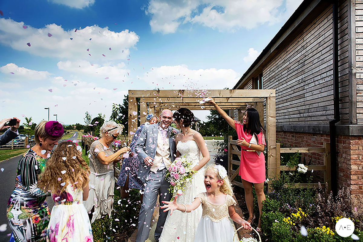 bride and groom confetti photo at mythe barn captured by documentary wedding photographer Alison Edwards