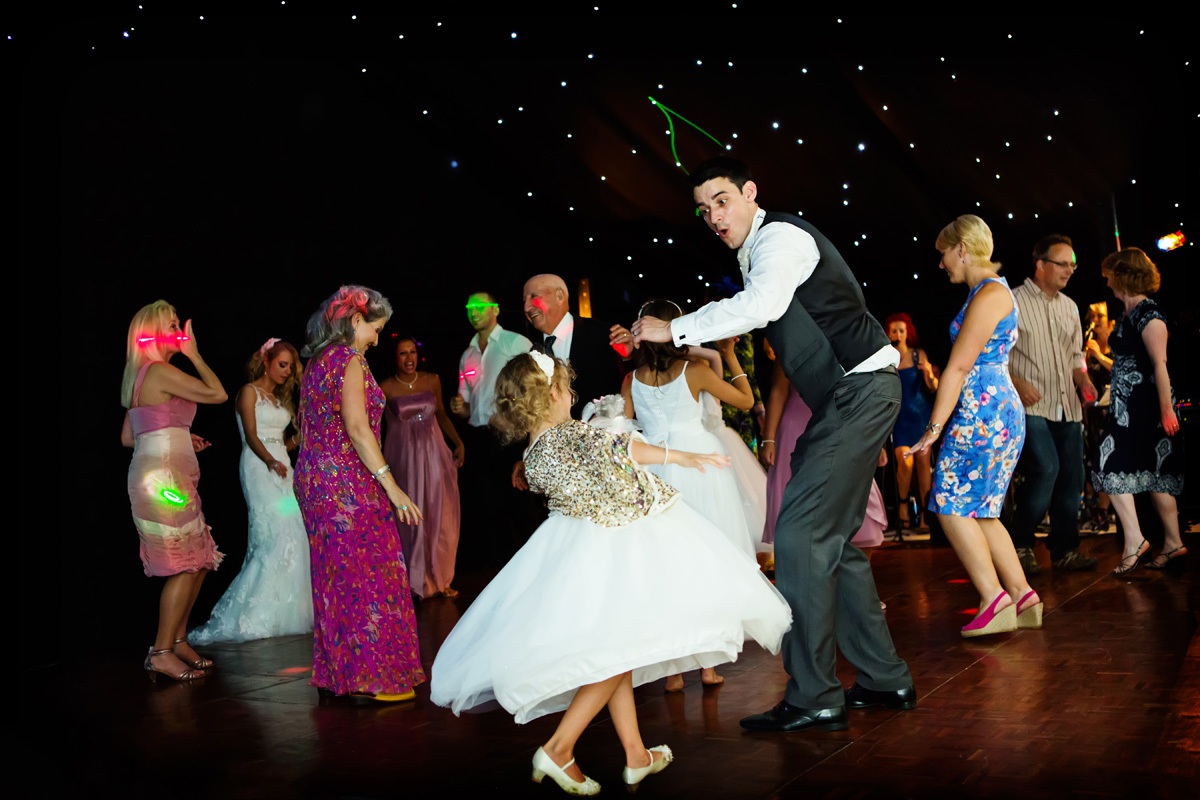 groom dancing with young bridesmaid captured by twilight wedding photographer Alison Edwards Photography
