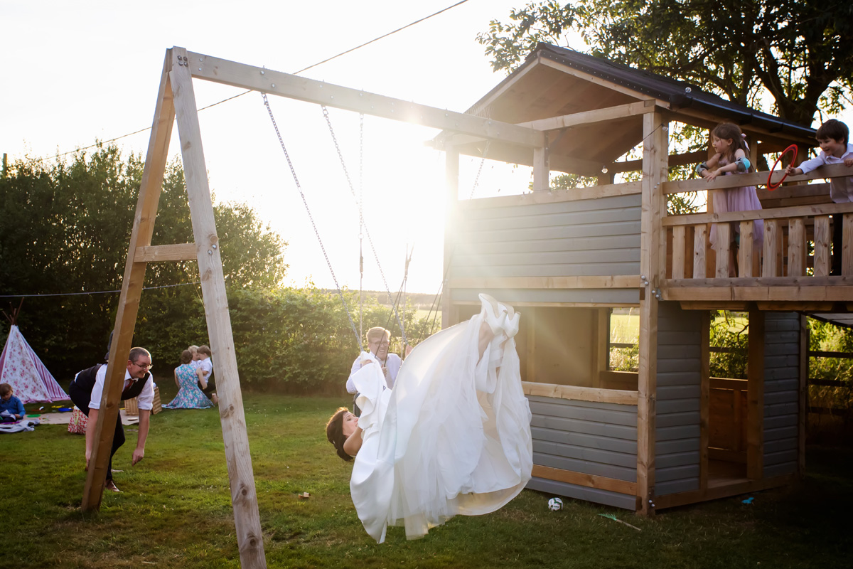 bride on a swing captured early evening by twilight wedding photographer Alison Edwards Photography