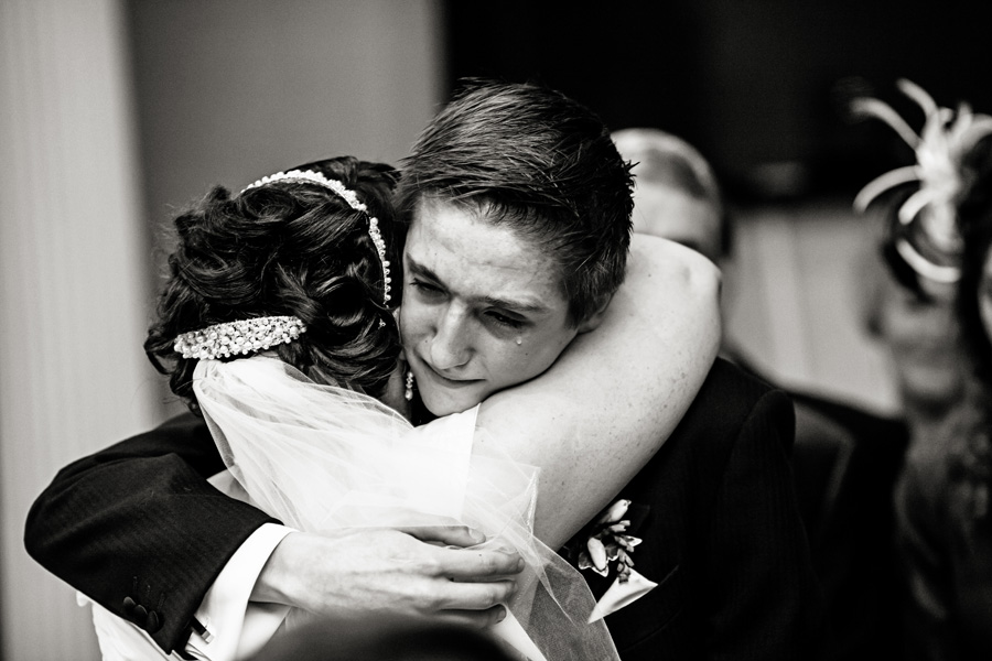 young man hugging bride and crying photographed by Chesterfield wedding photographer Alison Edwards Photography