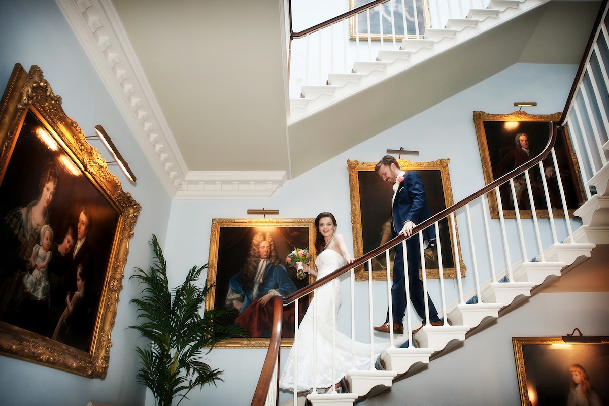 bride and groom walking down stairs at Norwood Park captured by Alison Edwards Photography on full day coverage collection