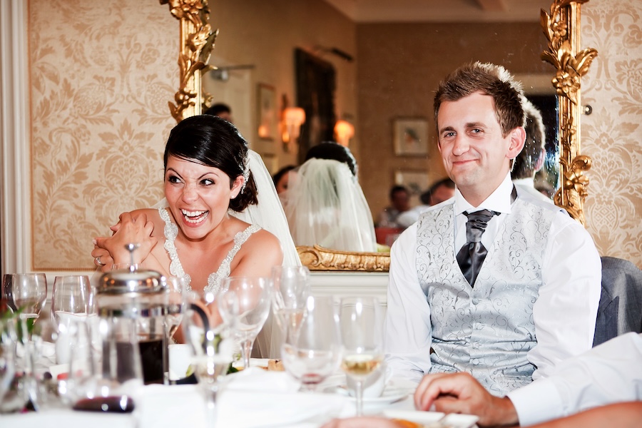 bride and groom laughing during speeches captured by Nottingham wedding photographer Alison Edwards photograph on a half-day coverage package