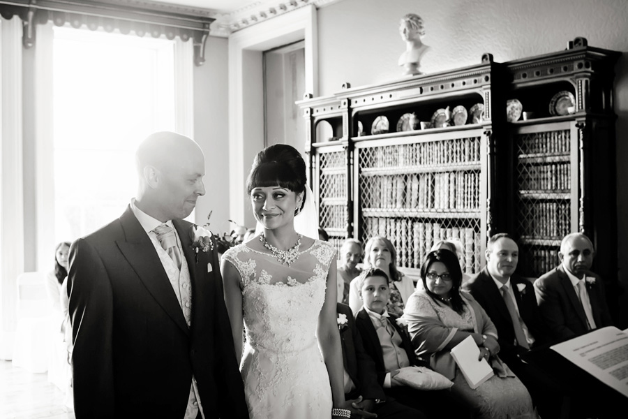 bride and groom smiling at alter at Prestwold Hall captured by Alison Edwards Photography based in Nottingham